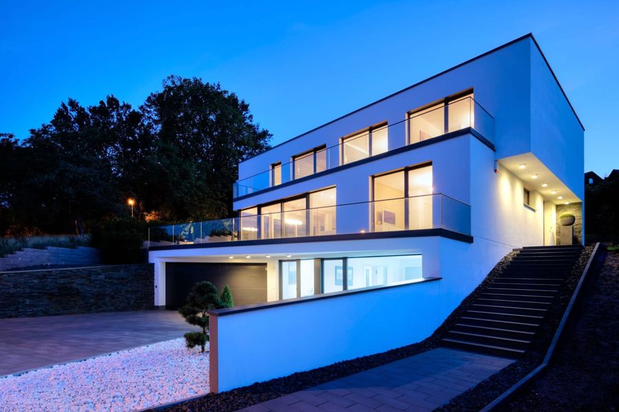 Modernes Haus zur Blauen Stunde mit beleuchteten Fenstern